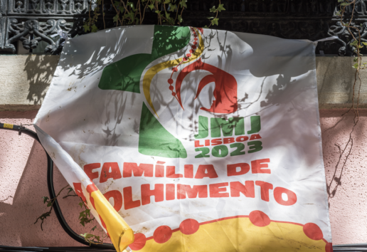 Bannière "Família de Olhimento" 2023, Lisbonne, avec logo vert et rouge, accrochée à un balcon.