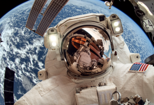 Spationaute en combinaison dans l'espace, devant la Terre, avec vue sur la station spatiale et drapeau américain.