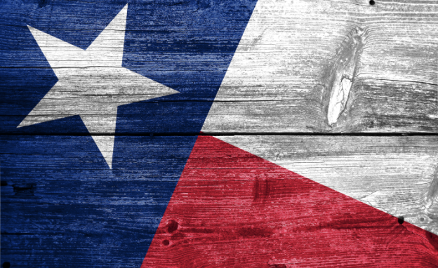 Image représentant le drapeau du Texas sur fond de bois vieilli et usé.
