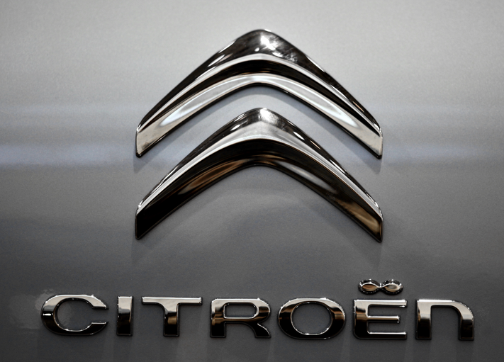 Logo Citroën : emblème métallique en forme de double flèche stylisée avec l'inscription "CITROËN" en lettres capitales.