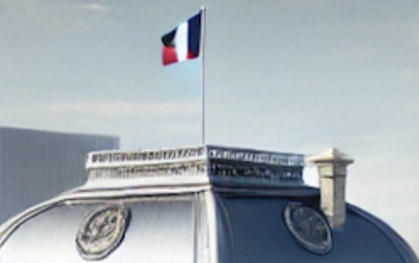 Bâtiment avec drapeau tricolore français flottant, devant façade blanche ornée de balustrades et de symboles gravés.